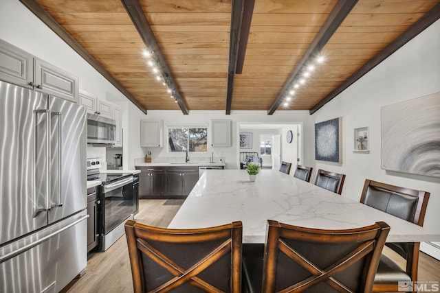 3430 Gwynelle Ct, Sparks, NV 89431 - kitchen with stainless steel appliances, wood ceiling, light wood-type flooring, a breakfast bar area, and a center island