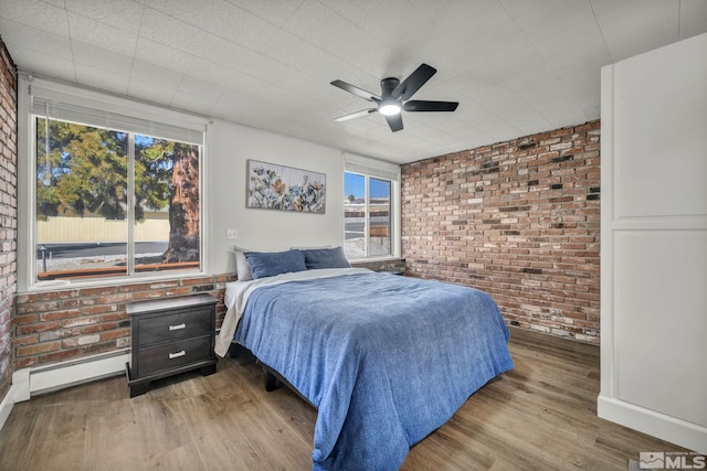 3430 Gwynelle Ct, Sparks, NV 89431 - bedroom featuring brick wall, wood finished floors, a ceiling fan, and a baseboard radiator