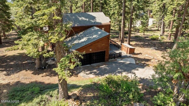 650 Tumbleweed Cir, Incline Village, NV 89451 - view of property exterior featuring a shingled roof, a garage, and a wooded view