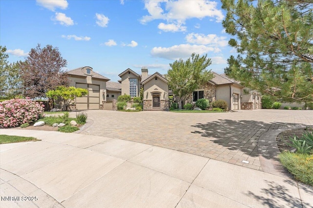 2550 Old Waverly Ct, Sparks, NV 89436 - view of front of house featuring stone siding, decorative driveway, a garage, and stucco siding