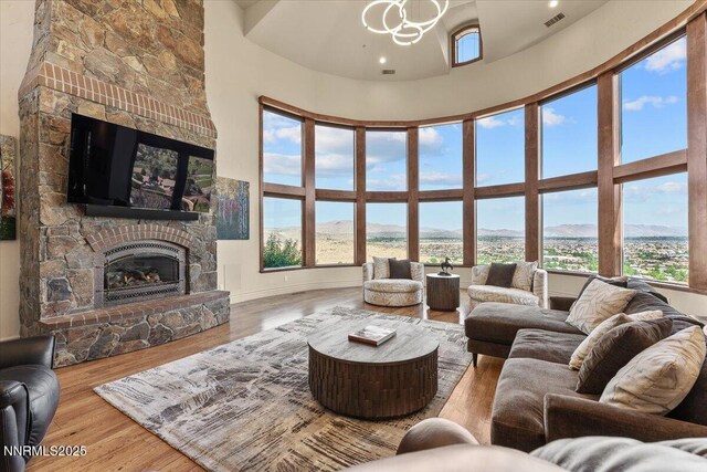 2550 Old Waverly Ct, Sparks, NV 89436 - living room featuring a fireplace, a high ceiling, wood finished floors, a mountain view, and a chandelier