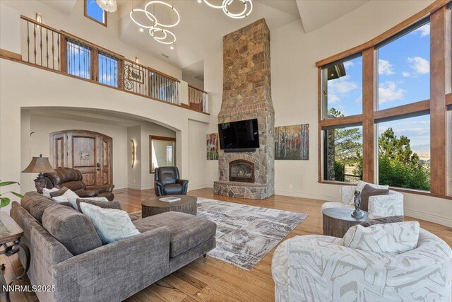 2550 Old Waverly Ct, Sparks, NV 89436 - living area with a towering ceiling, arched walkways, a fireplace, wood finished floors, and a chandelier