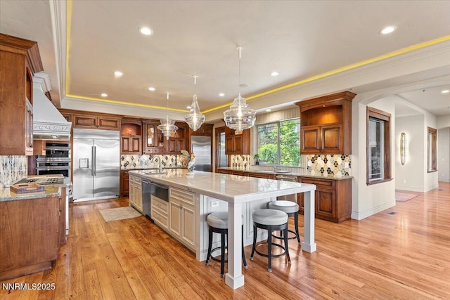 2550 Old Waverly Ct, Sparks, NV 89436 - kitchen with appliances with stainless steel finishes, a large island, tasteful backsplash, custom range hood, and a breakfast bar area