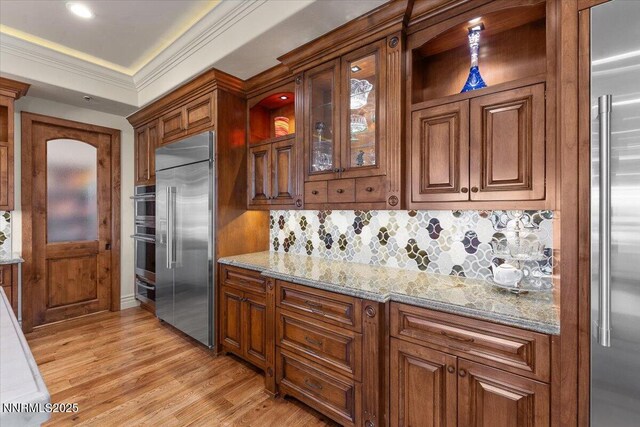 2550 Old Waverly Ct, Sparks, NV 89436 - kitchen featuring appliances with stainless steel finishes, backsplash, light wood-style flooring, light stone countertops, and crown molding