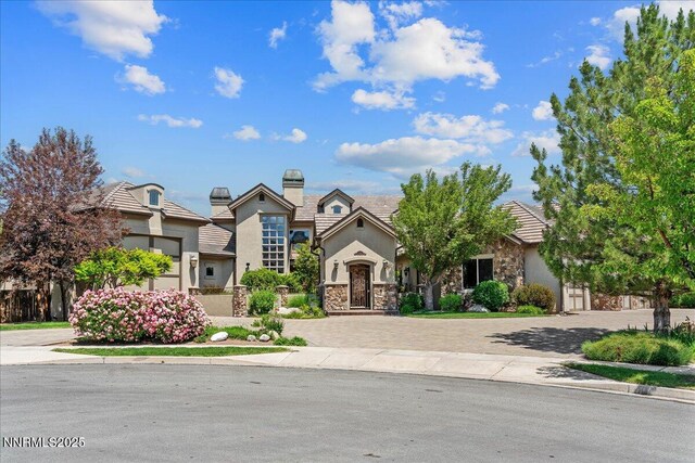 2550 Old Waverly Ct, Sparks, NV 89436 - view of front of property featuring stone siding, decorative driveway, stucco siding, and a chimney