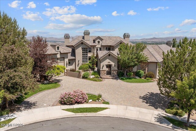 2550 Old Waverly Ct, Sparks, NV 89436 - view of front facade featuring stucco siding, curved driveway, a tile roof, stone siding, and a chimney