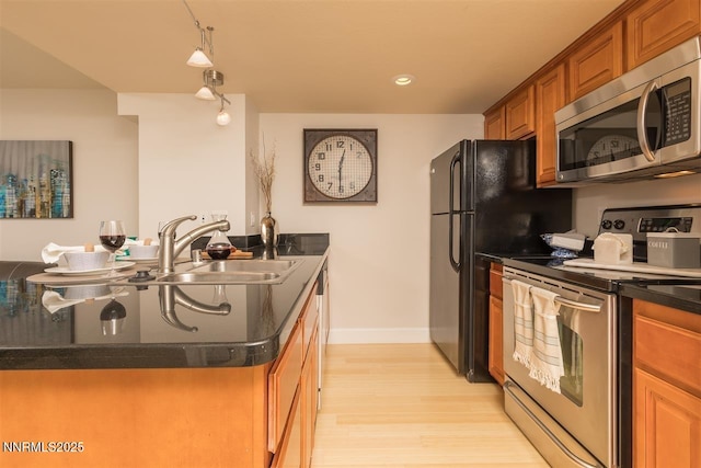 450 N Arlington Ave Unit 715, Reno, NV 89503 - kitchen with appliances with stainless steel finishes, light wood-style floors, brown cabinetry, and recessed lighting
