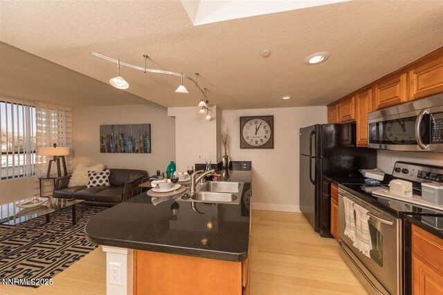 450 N Arlington Ave Unit 715, Reno, NV 89503 - kitchen with stainless steel appliances, light wood finished floors, dark countertops, brown cabinets, and open floor plan