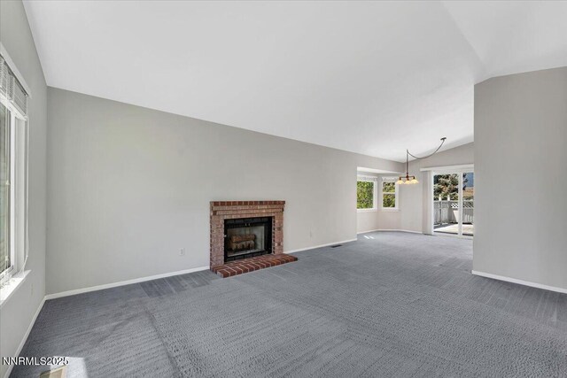 971 Shadow Ln, Carson City, NV 89705 - unfurnished living room featuring vaulted ceiling, carpet, a fireplace, and a chandelier