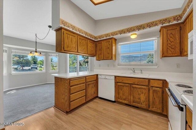 971 Shadow Ln, Carson City, NV 89705 - kitchen with white appliances, a peninsula, brown cabinetry, and healthy amount of natural light
