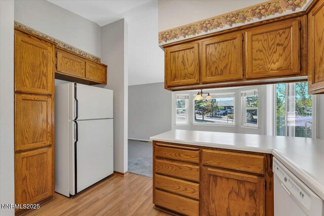 971 Shadow Ln, Carson City, NV 89705 - kitchen with white appliances, light wood finished floors, brown cabinets, and light countertops