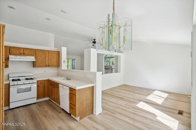 8589 Turtle Creek Ct, Reno, NV 89506 - kitchen with white appliances, under cabinet range hood, open floor plan, light countertops, and lofted ceiling