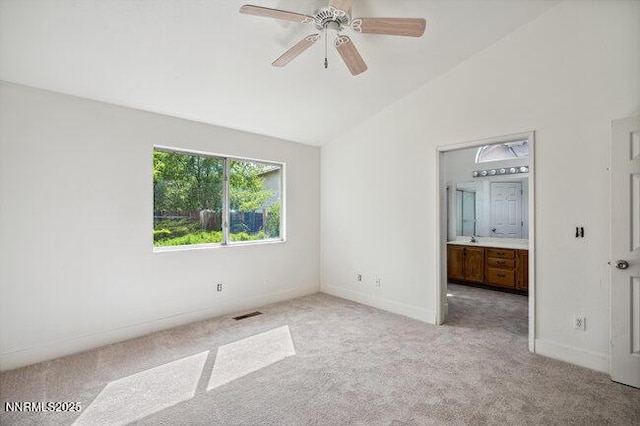 8589 Turtle Creek Ct, Reno, NV 89506 - unfurnished bedroom with lofted ceiling, light carpet, and connected bathroom