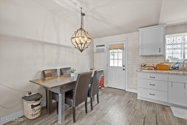 1510 E Slide Mountain Dr, Carson City, NV 89706 - dining space with light wood-type flooring, a chandelier, and a wall mounted air conditioner