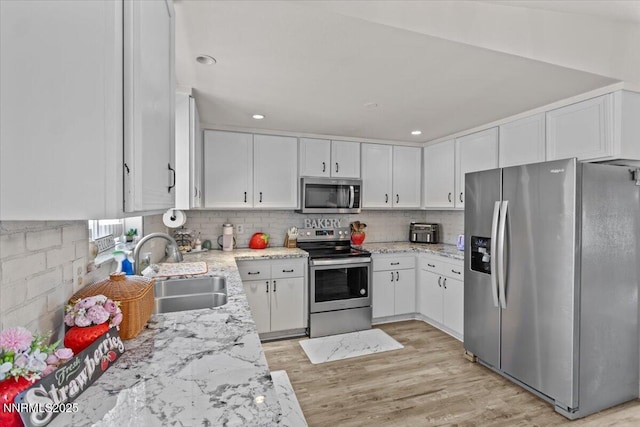 1510 E Slide Mountain Dr, Carson City, NV 89706 - kitchen featuring stainless steel appliances, white cabinetry, light wood-type flooring, light stone counters, and backsplash