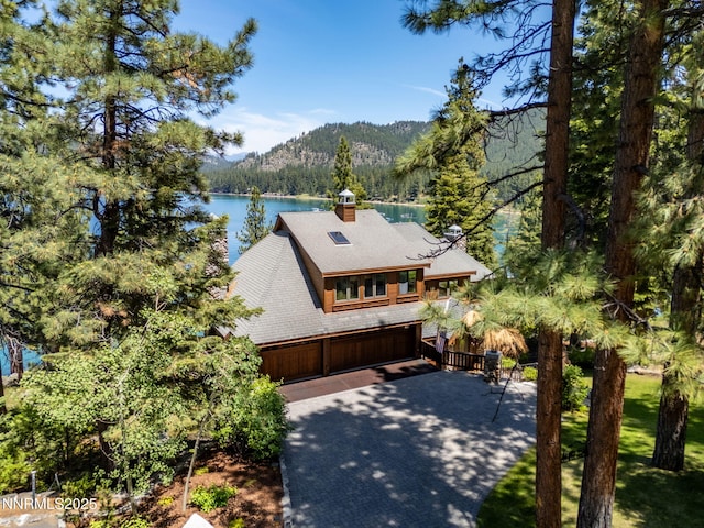 187 Yellow Jacket Rd, Glenbrook, NV 89413 - view of front of house with a view of trees, a chimney, a garage, a water and mountain view, and a shingled roof
