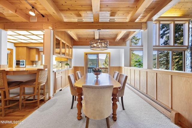 187 Yellow Jacket Rd, Glenbrook, NV 89413 - dining room with a chandelier, a wood ceiling with exposed beams, baseboard heating, a wainscoted wall, and light colored carpet