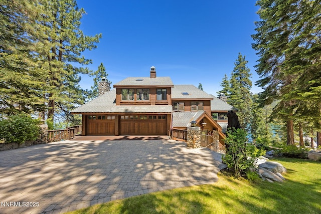 187 Yellow Jacket Rd, Glenbrook, NV 89413 - chalet / cabin featuring a chimney, decorative driveway, a garage, and a front lawn