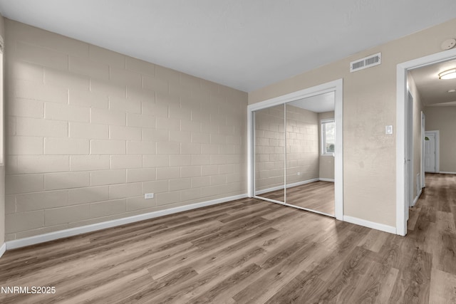 12102 Rocky Mountain St, Reno, NV 89506 - unfurnished bedroom featuring wood finished floors, a closet, and concrete block wall