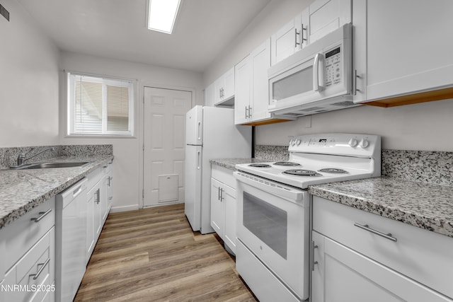 12102 Rocky Mountain St, Reno, NV 89506 - kitchen with white appliances, white cabinets, light wood-style floors, and light stone counters