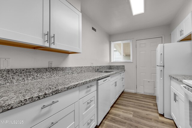 12102 Rocky Mountain St, Reno, NV 89506 - kitchen with white appliances, white cabinets, light stone countertops, and light wood-style flooring