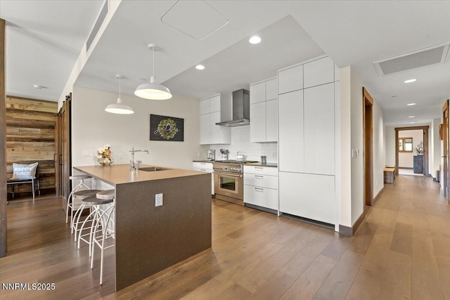 17 Beach Club Dr # 213, Stateline, NV 89449 - kitchen with wall chimney exhaust hood, stainless steel stove, modern cabinets, a breakfast bar area, and wooden walls