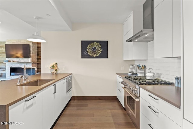 17 Beach Club Dr # 213, Stateline, NV 89449 - kitchen with wall chimney range hood, stainless steel stove, a peninsula, dark wood finished floors, and modern cabinets