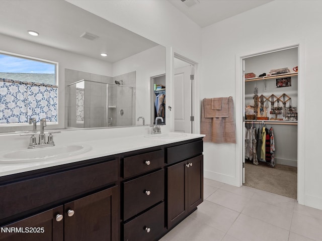 2217 Millville Dr, Spanish Springs, NV 89441 - bathroom featuring a stall shower, a walk in closet, double vanity, and tile patterned floors