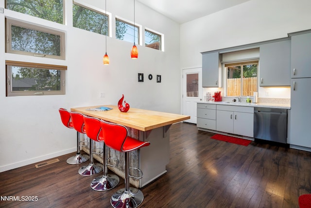 1264 Humboldt St, Reno, NV 89509 - kitchen featuring stainless steel dishwasher, a breakfast bar area, plenty of natural light, dark wood-style flooring, and a towering ceiling