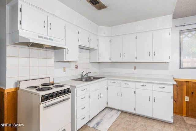 5385 Carol Dr, Sun Valley, NV 89433 - kitchen with electric stove, under cabinet range hood, light countertops, tasteful backsplash, and white cabinets