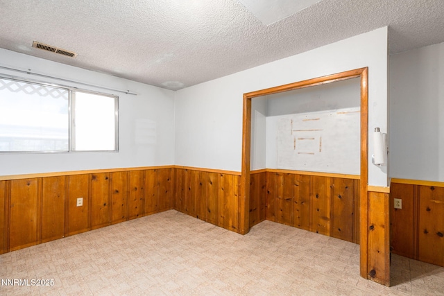 5385 Carol Dr, Sun Valley, NV 89433 - spare room featuring a wainscoted wall, wood walls, tile patterned floors, and a textured ceiling