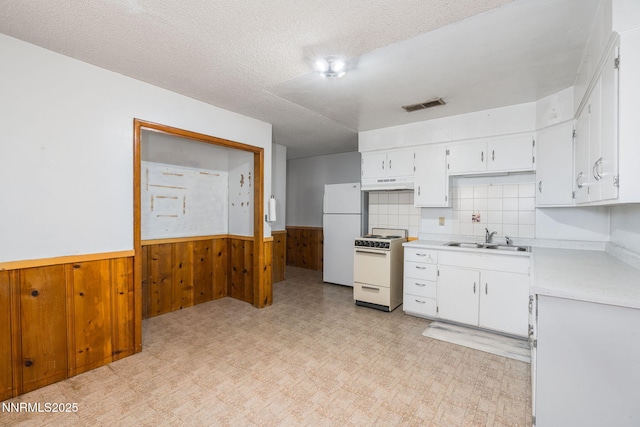 5385 Carol Dr, Sun Valley, NV 89433 - kitchen featuring white appliances, wainscoting, light countertops, light flooring, and wood walls