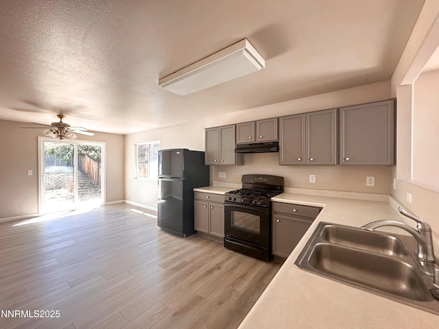 7420 Findhorn Dr, Reno, NV 89506 - kitchen with black appliances, gray cabinets, light wood-type flooring, a ceiling fan, and under cabinet range hood