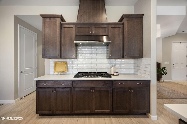 2021 Neviekay Ln, Reno, NV 89521 - kitchen with under cabinet range hood, stainless steel gas cooktop, light wood-style floors, and backsplash