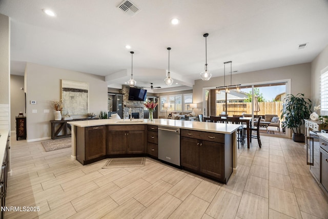 2021 Neviekay Ln, Reno, NV 89521 - kitchen with dishwasher, dark brown cabinets, open floor plan, light countertops, and a stone fireplace