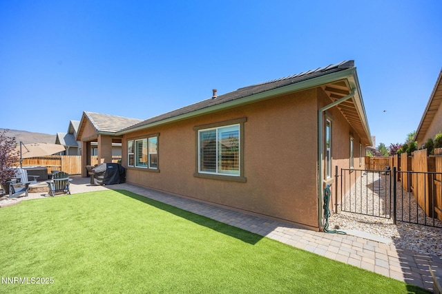2021 Neviekay Ln, Reno, NV 89521 - back of house featuring stucco siding, a fenced backyard, a patio, and an outdoor fire pit