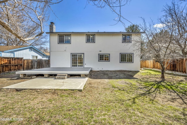 4565 Rio Encantado Ln, Reno, NV 89502 - back of property featuring a patio, a chimney, a fenced backyard, and a wooden deck