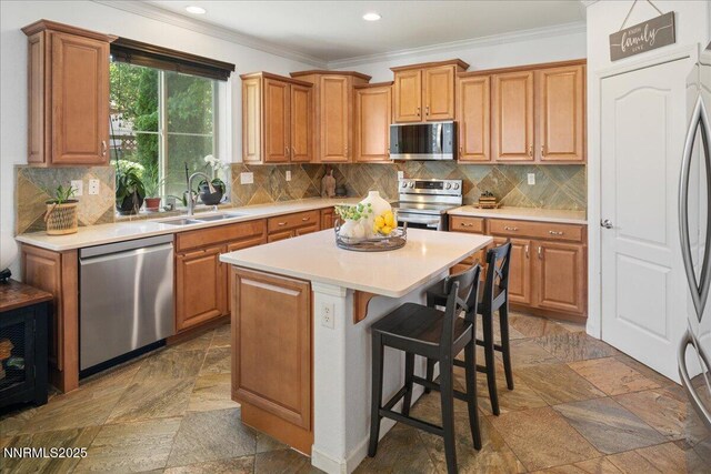 7470 Windswept Loop, Sparks, NV 89436 - kitchen with appliances with stainless steel finishes, crown molding, stone tile flooring, light countertops, and a kitchen island
