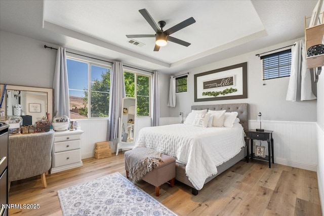 7470 Windswept Loop, Sparks, NV 89436 - bedroom featuring a tray ceiling, light wood-type flooring, wainscoting, and ceiling fan