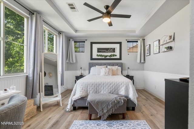 7470 Windswept Loop, Sparks, NV 89436 - bedroom with a tray ceiling, light wood finished floors, a wainscoted wall, and a ceiling fan