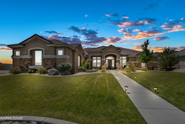 11575 Anthem Dr, Spanish Springs, NV 89441 - view of front of house with stucco siding, stone siding, and a lawn