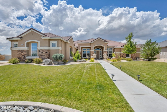11575 Anthem Dr, Spanish Springs, NV 89441 - mediterranean / spanish-style house featuring stone siding, stucco siding, a front yard, and a tiled roof