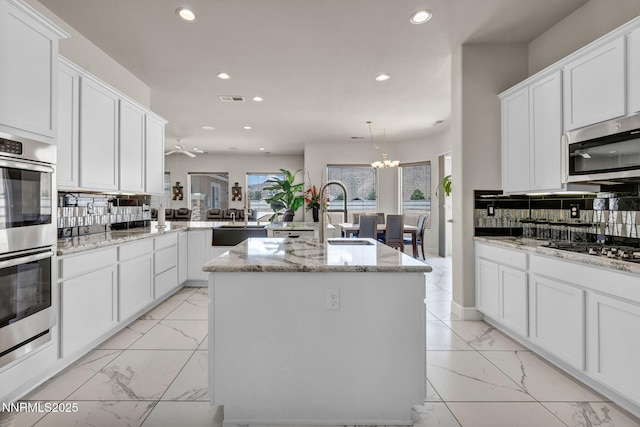 11575 Anthem Dr, Spanish Springs, NV 89441 - kitchen featuring light marble finish flooring, stainless steel appliances, recessed lighting, a peninsula, and decorative backsplash