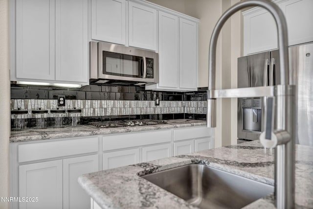 11575 Anthem Dr, Spanish Springs, NV 89441 - kitchen with stainless steel appliances, white cabinets, tasteful backsplash, and light stone countertops