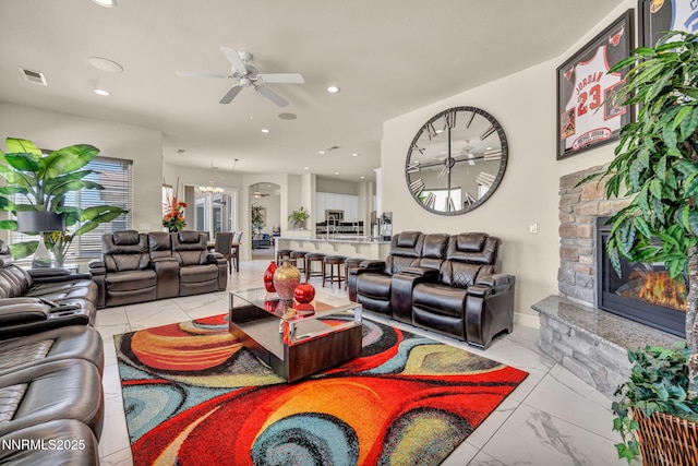 11575 Anthem Dr, Spanish Springs, NV 89441 - living area with a ceiling fan, a stone fireplace, light marble finish floors, recessed lighting, and a chandelier