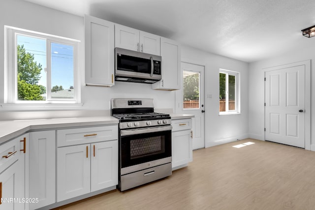 1125 Vance Way, Sparks, NV 89431 - kitchen featuring stainless steel appliances, light countertops, light wood-type flooring, white cabinets, and a textured ceiling
