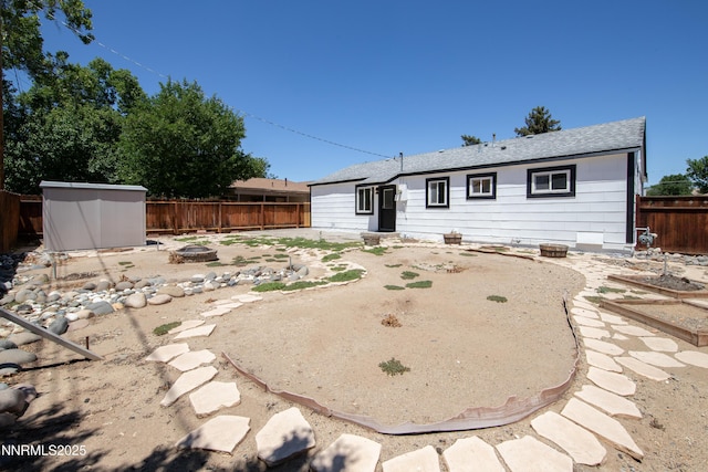 1125 Vance Way, Sparks, NV 89431 - rear view of house with a fire pit, a fenced backyard, a shed, and roof with shingles