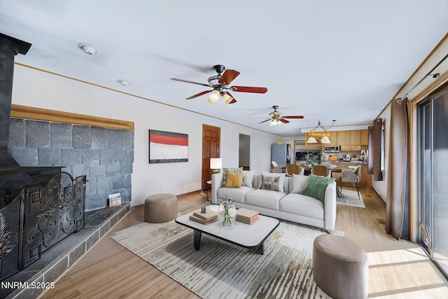 2260 Empire Rd, Reno, NV 89521 - living room featuring a wood stove, light wood-style flooring, and ceiling fan