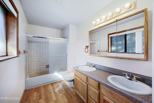 2260 Empire Rd, Reno, NV 89521 - bathroom featuring wood finished floors, double vanity, and bath / shower combo with glass door
