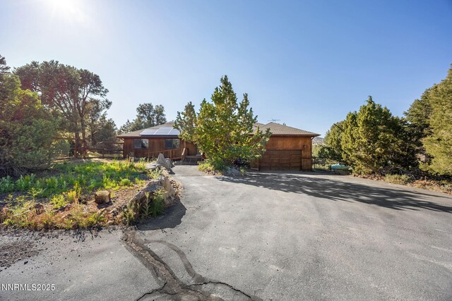 2260 Empire Rd, Reno, NV 89521 - view of front of home with asphalt driveway, a garage, and solar panels